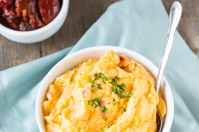 Bowl of mashed potatoes next to bowl of La Preferida Chipotle peppers used to make Chipotle Mashed Potatoes.