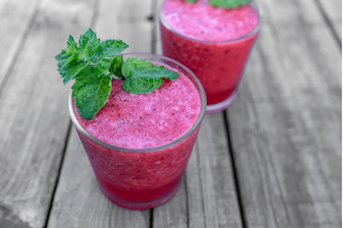 Pitcher of Watermelon Agua Fresca with cherries, lime slices, and fresh mint served over ice.