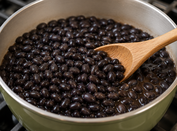 Black beans heating in a saucepan on the stovetop as part of a guide to cooking canned beans.